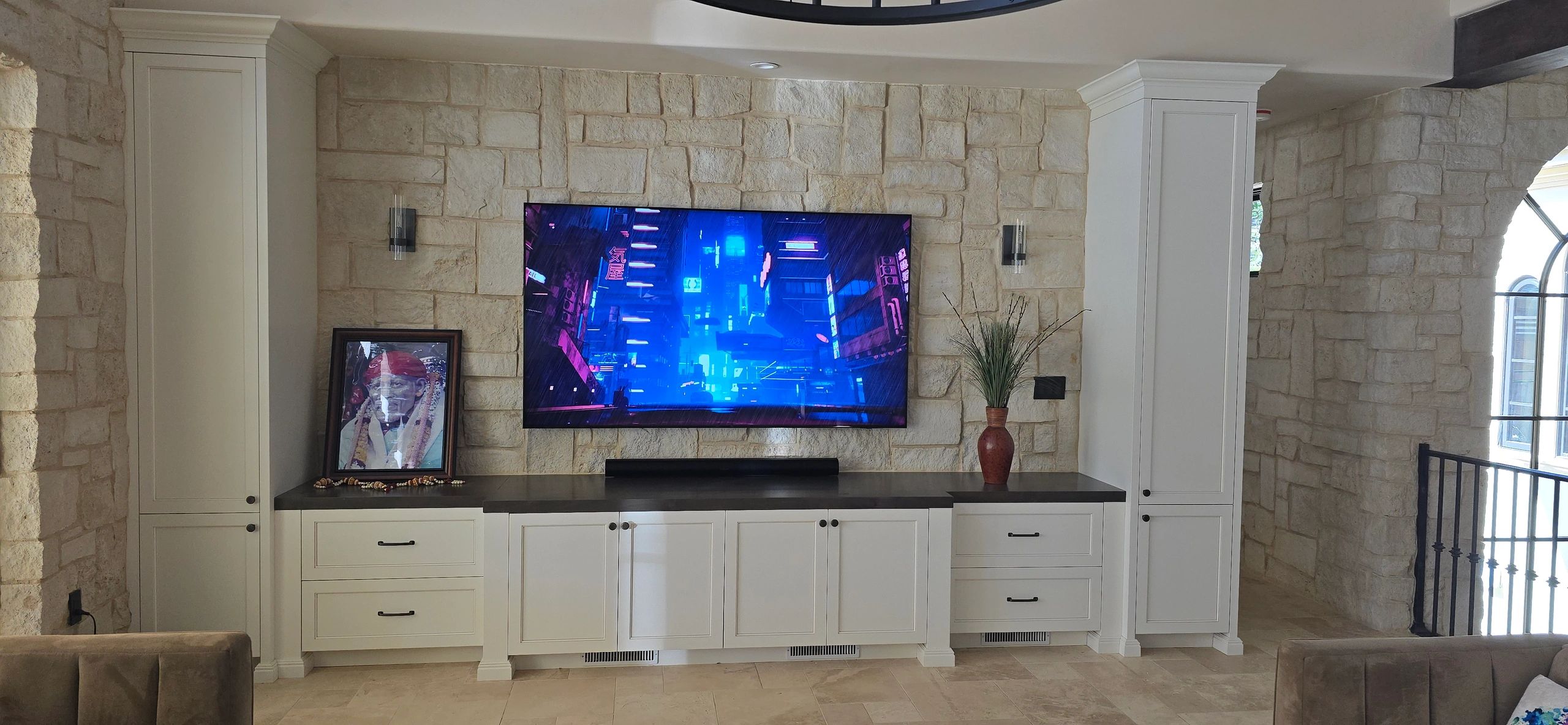 Completed TV installation on a stone wall with concealed cables